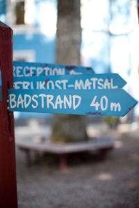 zwei blaue Straßenschilder an einer roten Stange in der Unterkunft Beach House Ystad in Ystad