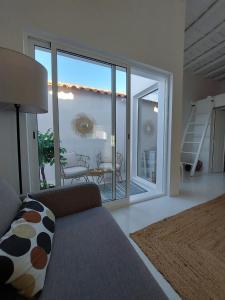 a living room with a couch and a balcony at Casa Coral in São Marcos do Campo