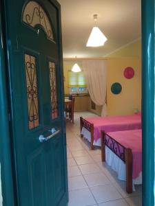 pokój z 2 łóżkami i zielonymi drzwiami w obiekcie Villa Ladina w mieście Ligia