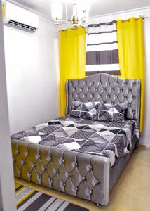 1 dormitorio con 1 cama en una habitación con cortinas amarillas en Apartamento en la carreras próximo al monumento, en Santiago de los Caballeros