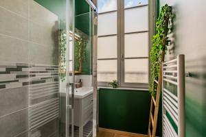 a bathroom with a shower and a sink with plants at Appartement Jungle - Libourne Centre - 4 pers - Sauna - Netflix in Libourne