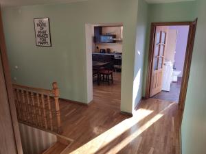 a hallway with a staircase leading to a living room at Spacious & Cozy Apartment with Forest View in Zapyškis