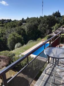 balcón con mesa y vistas a una colina en Posada Miralejos en Trapiche