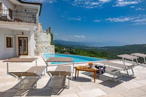 un patio con tavolo, sedie e piscina di Villa Evas Castle Crikvenica Riviera a Bribir