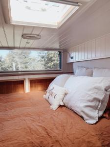 łóżko w środku pokoju z oknem w obiekcie Relaxing retreat for 2 on beautiful converted bus w mieście Levaré