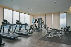 a gym with cardio equipment in a building with windows at Sky pool 4 star hotel grade stay in i-City in Shah Alam