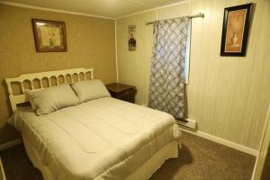 a bedroom with a white bed with a window at 3-Bedroom apt. ideal location near new river gorge in Fayetteville