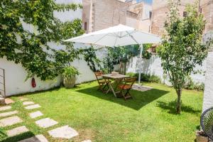 a table and chairs with an umbrella in a yard at meridiano12 in Favignana