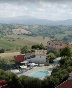 eine Villa mit einem Pool und einem Gebäude in der Unterkunft Colle Regnano in Tolentino