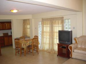 a living room with a table and a tv at JerryDon's Apartment in Saint Georgeʼs