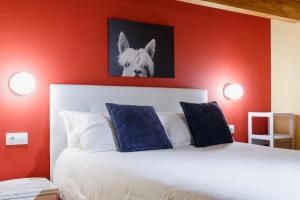 a bedroom with red walls and a white bed with blue pillows at AndBnB I Duplex Rustico en Plena Naturaleza I Parking Gratis in Canillo