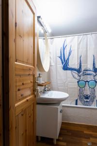 La salle de bains est pourvue d'un lavabo et d'un rideau de douche pour les cerfs. dans l'établissement AndBnB I Duplex Rustico en Plena Naturaleza I Parking Gratis, à Canillo
