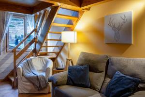 a living room with a couch and a staircase at AndBnB I Duplex Rustico en Plena Naturaleza I Parking Gratis in Canillo