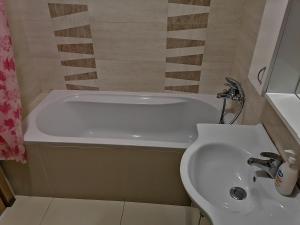uma casa de banho com um lavatório e uma banheira em Apartman Sara em Pržno