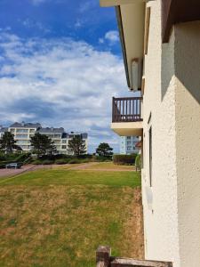 budynek z balkonem i podwórkiem z budynkami w obiekcie La plage w mieście Courseulles-sur-Mer