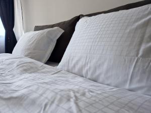 an unmade bed with white sheets and pillows at Apartment Enya in Burgas