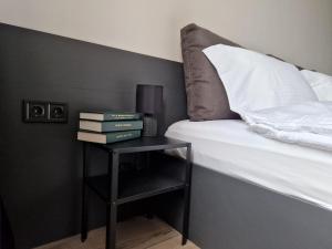 a side table with a bed and books on it at Apartment Enya in Burgas City