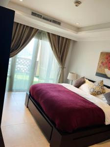 a bedroom with a large bed and a large window at Luxury 2 bedroom Apt in The Pearl with Marina view in Doha