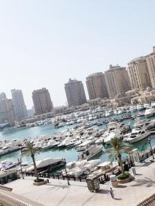 a group of boats in a harbor in a city at Luxury 2 bedroom Apt in The Pearl with Marina view in Doha