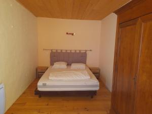 a small bedroom with a bed and a wooden floor at Appartement individuel rez de jardin 3 a 5 personnes proche Albi in Cadalen
