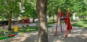 a park with a playground with a tree and a ladder at Apartman Aria in Dugi Rat