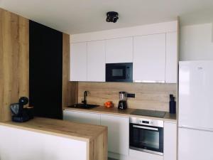 a kitchen with white cabinets and a white refrigerator at Apartman Aria in Dugi Rat