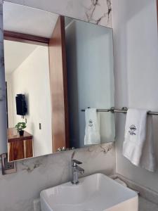 a bathroom with a sink and a mirror at AZUL ARENA Hotel Boutique in Mazatlán