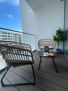 a balcony with a chair and a table with a cup of coffee at Apartament Nadmorski - Plac Unii - Parking in Gdynia