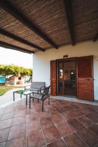een patio met een bank en een tafel bij Agriturismo Irghitula in Posada