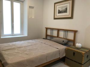 ein Schlafzimmer mit einem Bett und einem Fenster in der Unterkunft Entre mer, rivière et montagne f2 avec terrasse :) in Pailhès