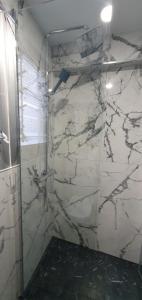 y baño con ducha y pared de mármol. en ¡Económico y bien ubicado!, en Castellón de la Plana