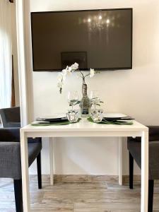 a white table with glasses and a vase with flowers at Leonardo & Davide Apartment Florence in Florence