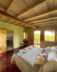 una camera con un grande letto e un soffitto in legno di Gulupa Ecolodge a Jardin