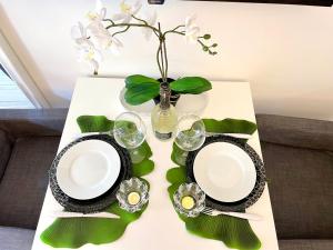 a table with plates and glasses and a vase with flowers at Leonardo & Davide Apartment Florence in Florence +13 photos
