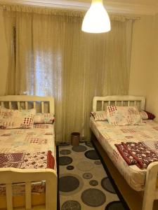 1 Schlafzimmer mit 2 Betten und einem Fenster in der Unterkunft blue bay sokhna aqua park - مارسيليا بلو باى السخنه -عائلات فقط in Ain Suchna