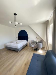 1 dormitorio con 1 cama, mesa y sillas en Dubois Apartments Kołobrzeg en Kołobrzeg