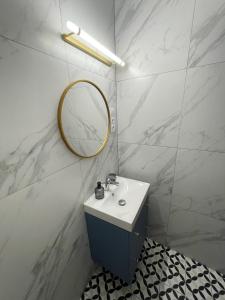W łazience znajduje się umywalka i lustro. w obiekcie Dubois Apartments Kołobrzeg w Kołobrzegu