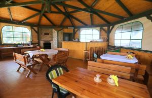 a restaurant with wooden tables and chairs and windows at Sosnowa Oaza in Baranów Sandomierski