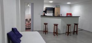 a room with a bar with stools and a bed at KITNET COM GARAGEM BARRA DO JUCU in Vila Velha