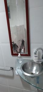 a bathroom with a sink and a mirror at KITNET COM GARAGEM BARRA DO JUCU in Vila Velha