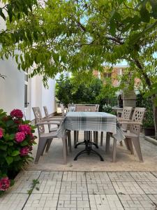 a table and chairs on a patio under a tree at Guest House Fjolla in Ulcinj