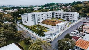 eine Draufsicht auf ein weißes Gebäude mit einem grünen Dach in der Unterkunft Urban Flats Studios by Corporate Stays in San José