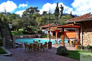 a pool with a table and chairs next to a house at Hosteria Duran in Cuenca