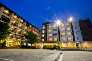 an empty parking lot in front of a building at night at Sinsuvarn Airport Suite Hotel SHA Extra Plus Certified B5040 in Lat Krabang