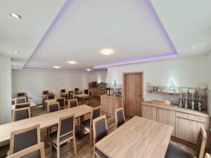 une salle à manger avec des tables et des chaises en bois dans l'établissement Hotel Pension Nordzeit, à Norddeich