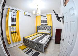mały pokój z łóżkiem i żółtymi zasłonami w obiekcie Apartamento en la carreras próximo al monumento w mieście Santiago de los Caballeros