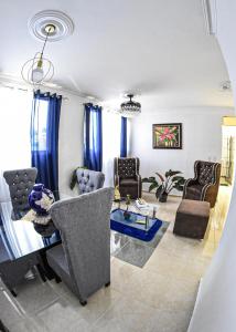 a living room with blue curtains and chairs at Apartamento en la carreras próximo al monumento in Santiago de los Caballeros