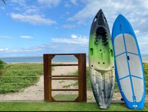 two surfboards are standing next to a wooden door at Casa Kala "Uma experiência beira-mar" in Porto De Galinhas