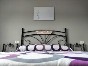 a bedroom with a black bed with purple and white pillows at O Vendaval in Corcubión