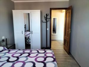 a bedroom with a bed with a purple and white blanket at O Vendaval in Corcubión